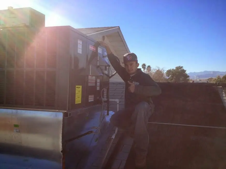 HVAC technician performing Heat Pump Repair on a rooftop unit in Ballwin